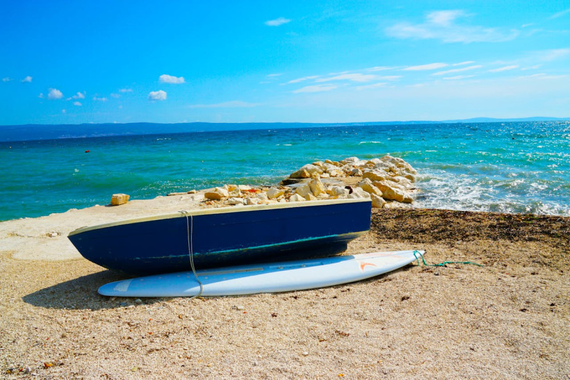 Kiesstrand mit Boot und klarem Adriawasser