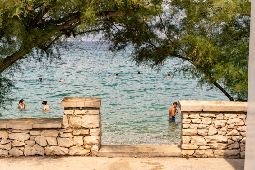 Schwimmer im klaren Wasser an einem kroatischen Steinstrand